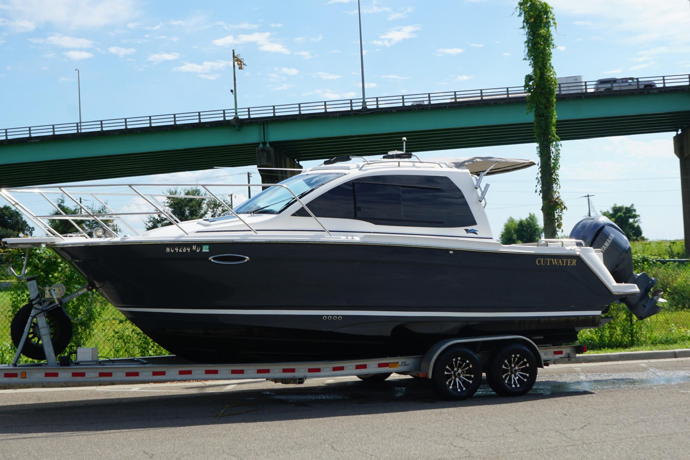 Cutwater C-248 Coupe 2022 Cutwater C-248 Coupe boat on trailer near a bridge, sunny day.