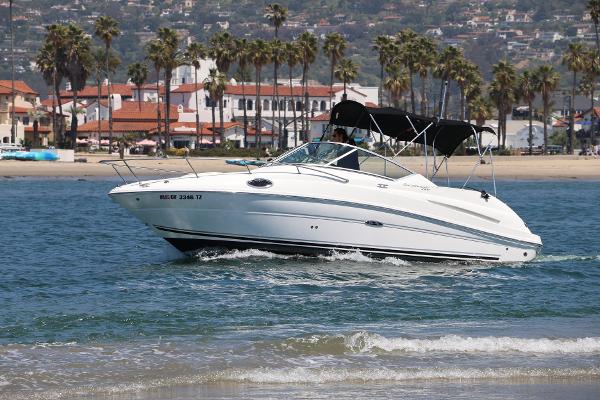 Sea Ray 240 Sundancer 2009 Sea Ray 240 Sundancer cruising near a scenic beach with palm trees.