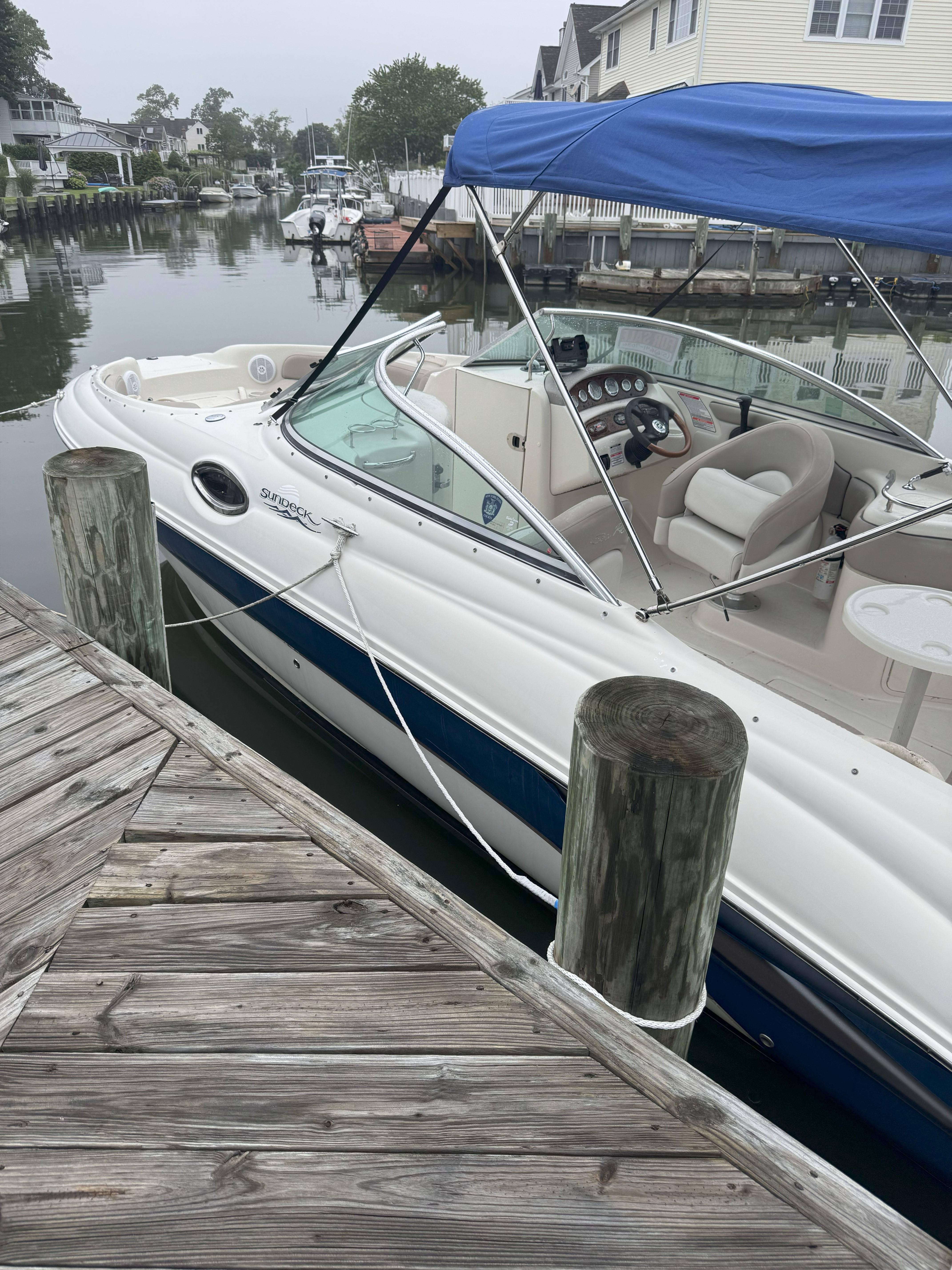 Sea Ray 240 Sundeck 2004 Sea Ray 240 Sundeck boat docked with blue canopy and white interior.