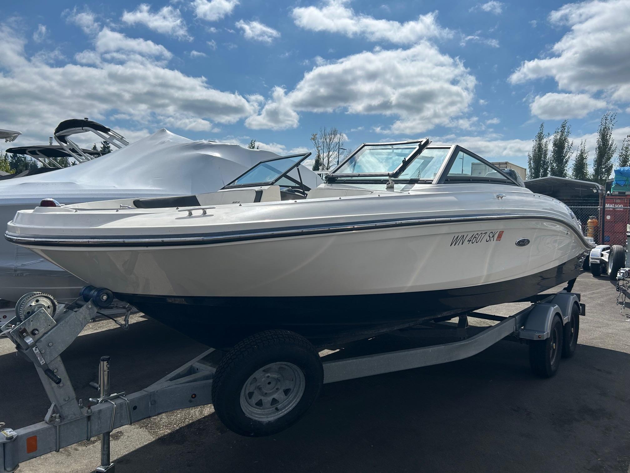 Sea Ray 21 SPX OB 2016 Sea Ray 21 SPX OB boat on trailer under a partly cloudy sky.