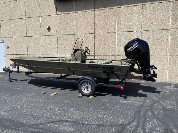 Tracker Grizzly 1860 CC 2024 Tracker Grizzly 1860 CC boat with Mercury engine on trailer, parked outdoors.