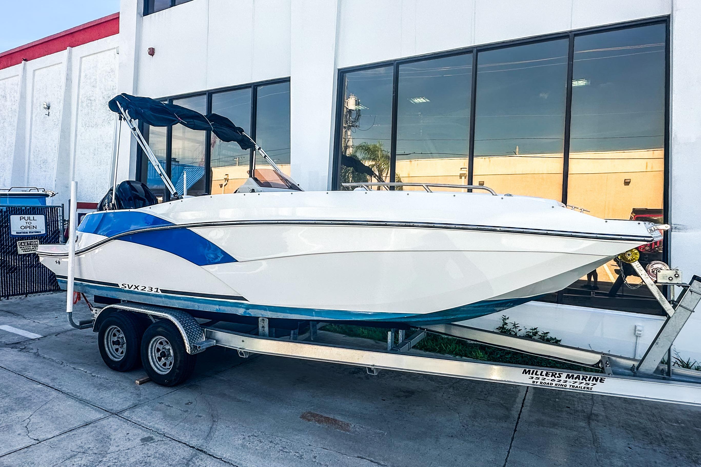 Starcraft SVX 231 OB DH 2022 Starcraft SVX 231 OB DH boat on trailer outside a building.