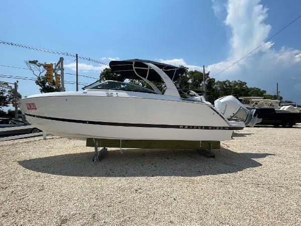Four Winns H6 OB 2025 Four Winns H6 OB boat on display in a gravel lot.