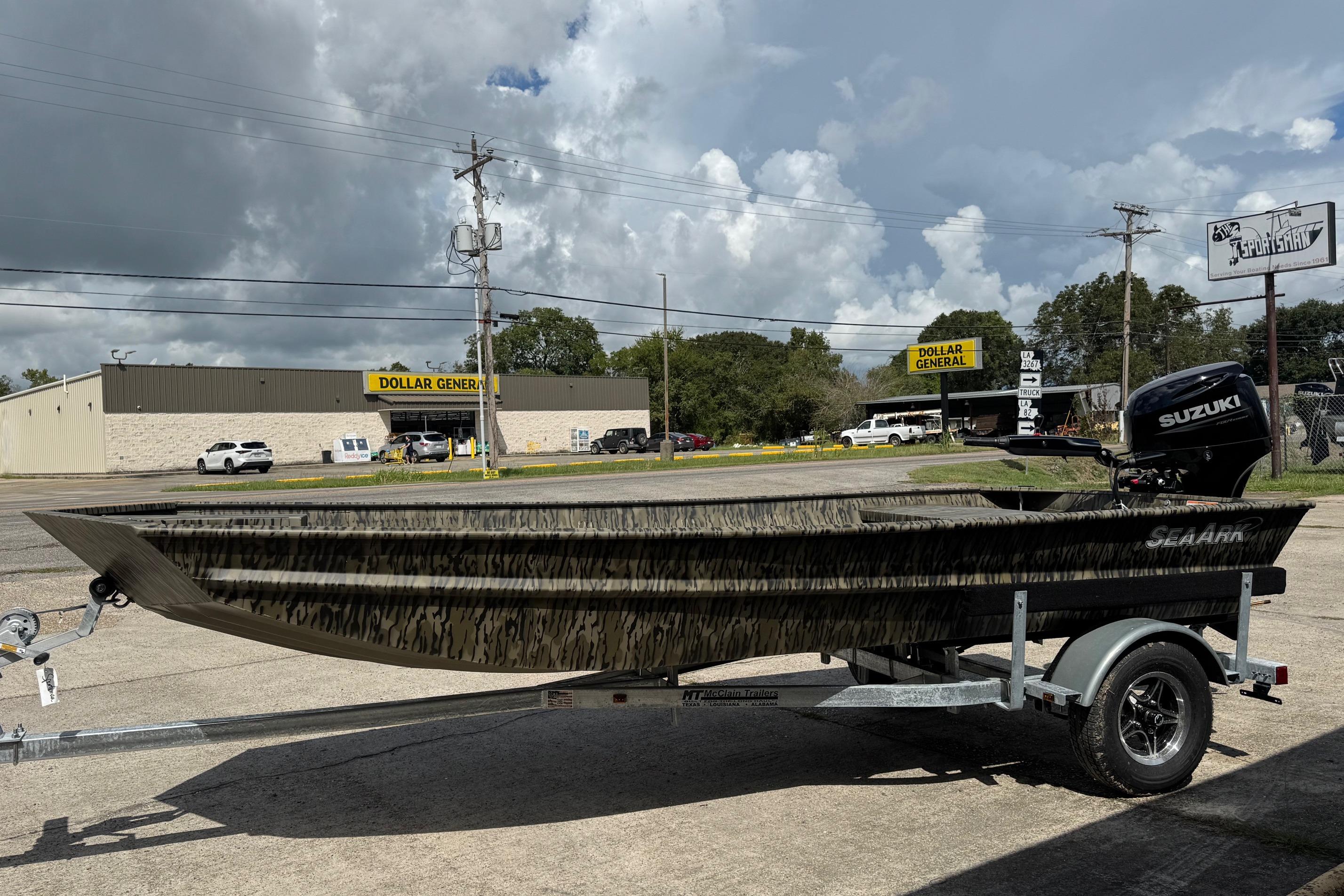 SeaArk 1652 Special 2026 SeaArk 1652 Special boat on trailer, parked near Dollar General under cloudy sky.