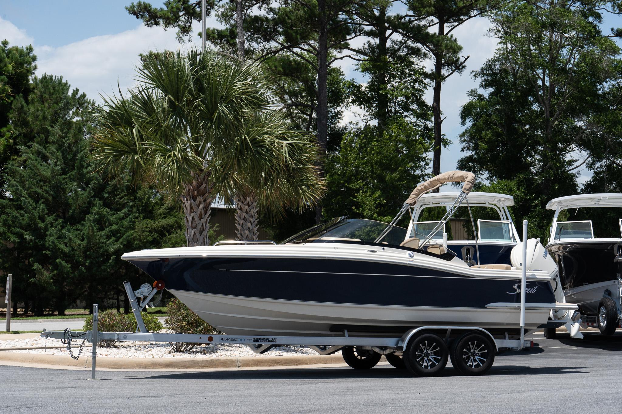 Scout 215 Dorado 2026 Scout 215 Dorado boat on trailer, parked near palm trees.