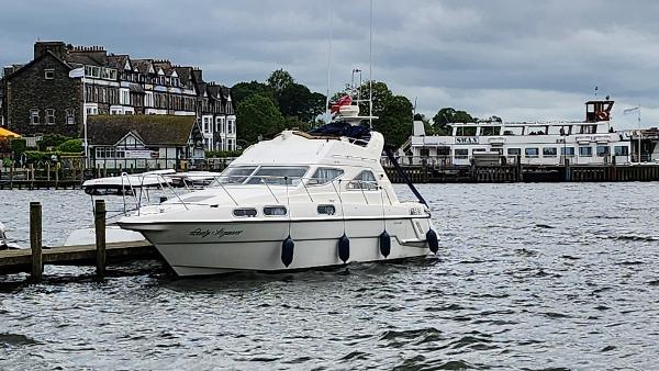 Sealine 320 Statesman 1994 Sealine 320 Statesman yacht docked by a scenic waterfront with buildings in the background.
