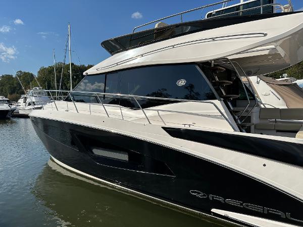 Regal 42 FXO 2021 Regal 42 FXO luxury yacht docked in a marina under clear skies.
