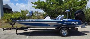 Nitro Z18 2025 Nitro Z18 boat on trailer, parked outdoors, blue and white design.
