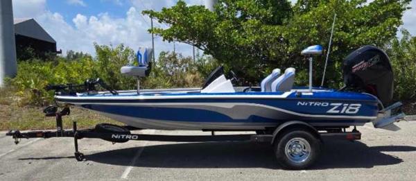 Nitro Z18 2025 Nitro Z18 boat on trailer, parked outdoors, blue and white design.