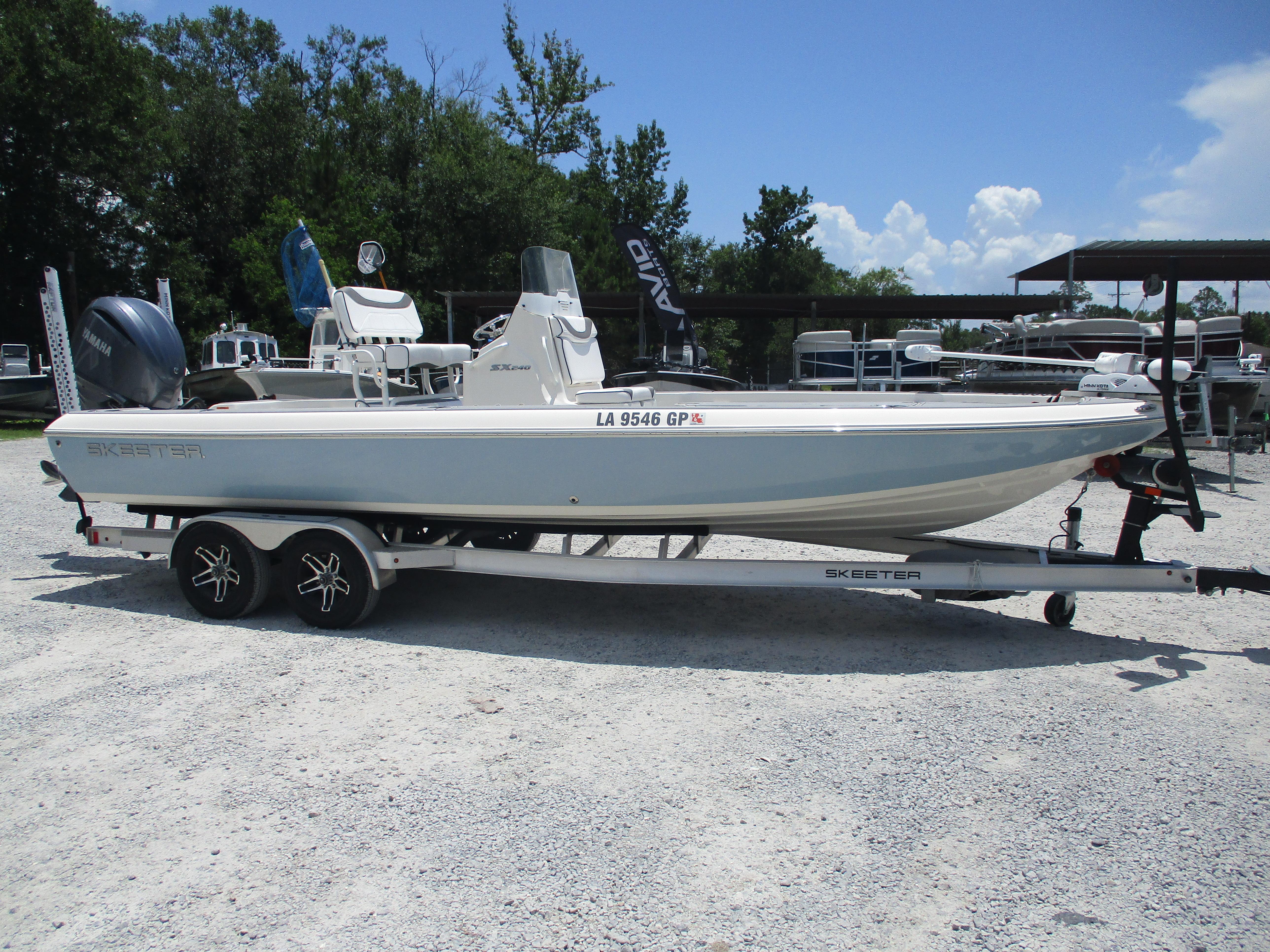 Skeeter SX 240 2023 Skeeter SX 240 boat on trailer, parked outdoors under clear sky.