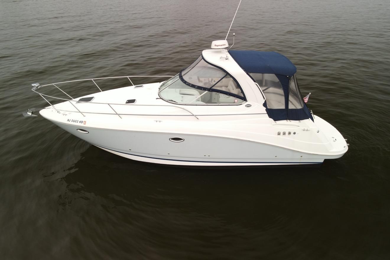 Rinker 340 Express Cruiser 2009 Rinker 340 Express Cruiser on calm water, featuring sleek white design and blue canopy.