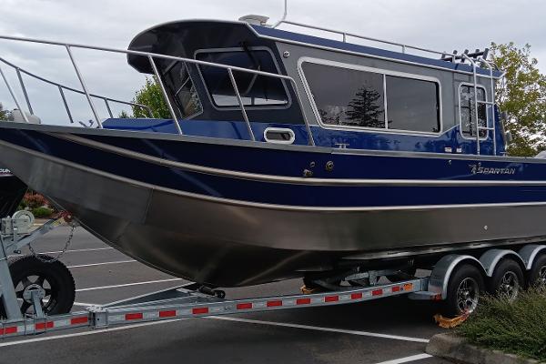 Spartan 2800 Olympia 2025 Spartan 2800 Olympia boat on trailer in parking lot.