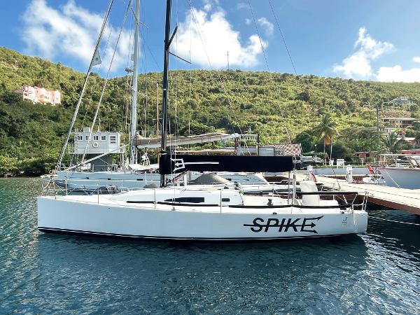 J Boats J/111 2015 J Boats J/111 sailboat docked in a scenic marina with lush hills.