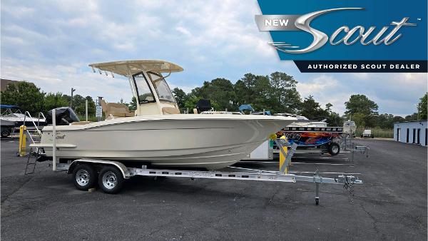 Scout 215 XSF 2024 Scout 215 XSF boat on trailer at authorized dealer, under cloudy sky.