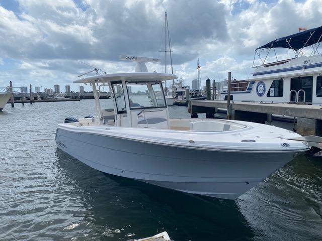 Robalo R302 Center Console 2022 Robalo R302 Center Console boat docked in a marina under cloudy skies.