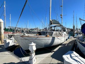 CAL 2-46 1974 CAL 2-46 sailboat docked at marina under clear blue sky.
