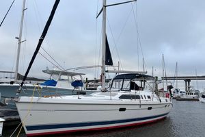 Hunter Passage 450 2000 Hunter Passage 450 sailboat docked in marina, overcast sky, bridge in background.