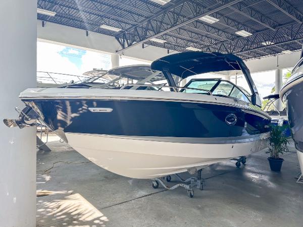 Chaparral 270 OSX 2025 Chaparral 270 OSX OB boat in showroom, blue and white exterior, under bright lighting.