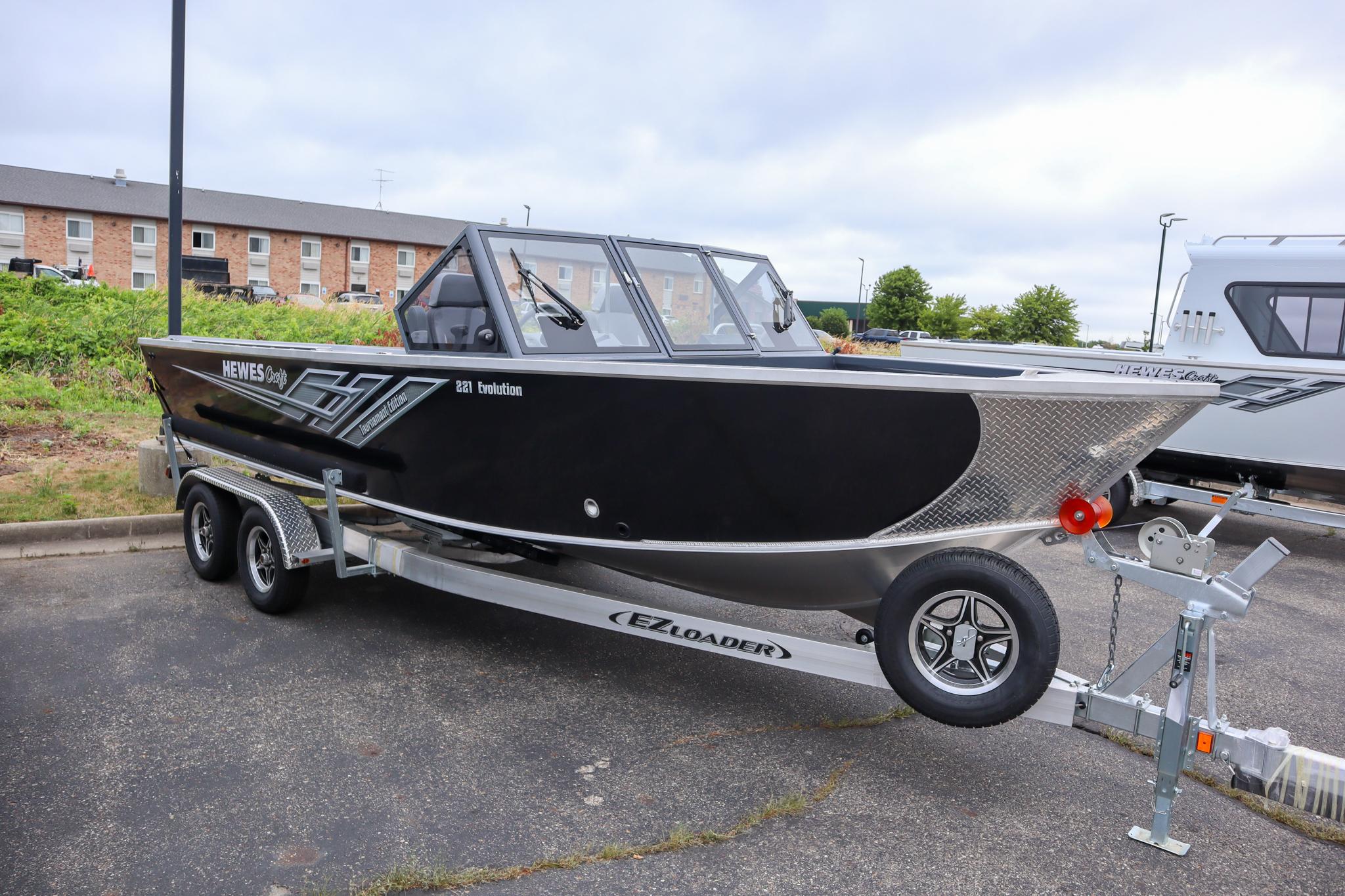 Hewescraft 221 Evolution Tournament Ed 2025 Hewescraft 221 Evolution Tournament Edition boat on trailer in parking lot.
