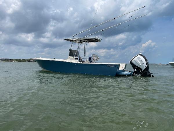 Mako 251 1989 Mako 251 boat on water, blue hull, outboard motor, cloudy sky background.