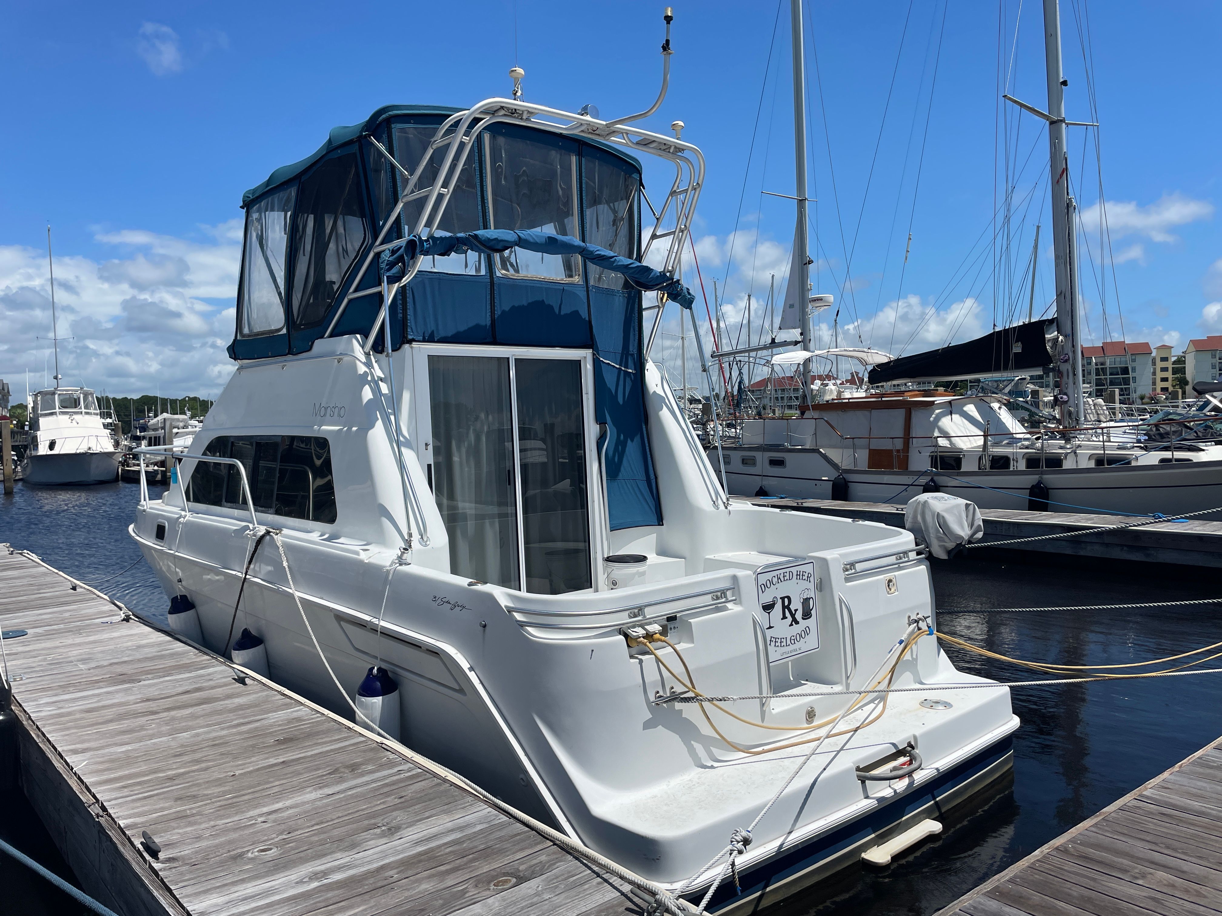 Mainship 31 Sedan Bridge 1996 Mainship 31 Sedan Bridge yacht docked at marina under clear blue sky.