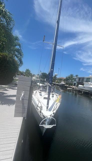 Hunter 35 1987 Hunter 35 sailboat docked in a sunny canal, surrounded by palm trees.
