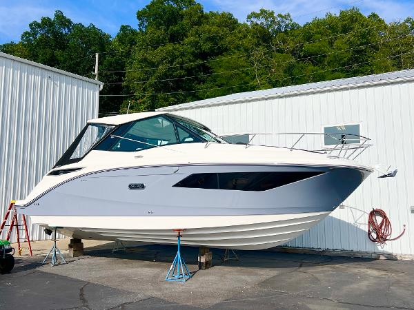 Sea Ray 320 Sundancer 2025 Sea Ray Sundancer 320 boat on stands near white building.