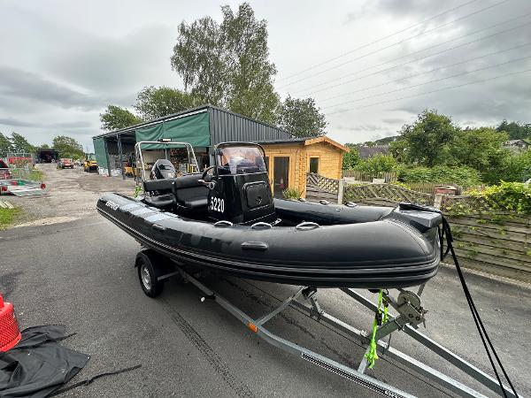 Brig Navigator 570 2020 Brig Navigator 570 boat on trailer, parked outdoors near buildings and greenery.