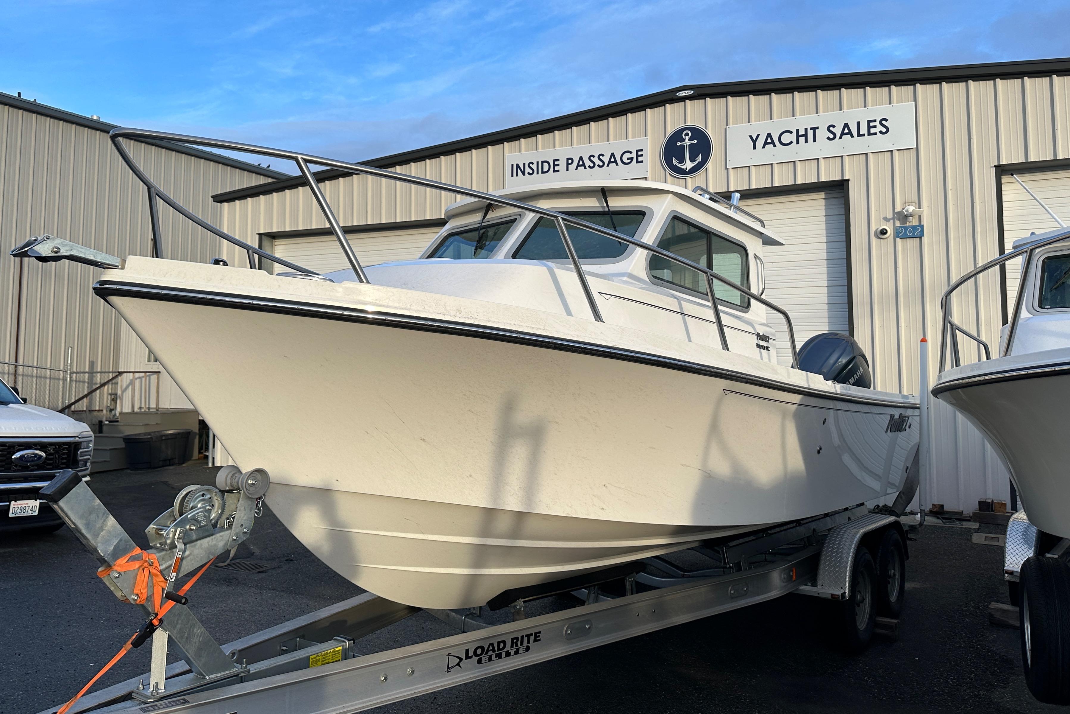 Parker 2420 Sport Cabin 2025 Parker 2420 Sport Cabin boat on trailer at yacht sales dealership.