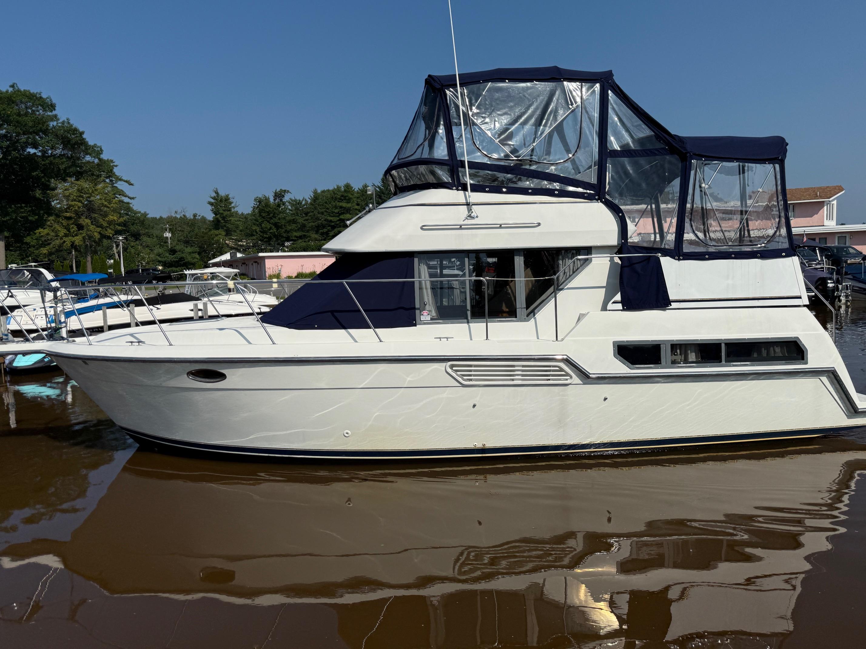 Carver 325 Aft Cabin 1995 Carver 325 Aft Cabin boat docked in marina under clear blue sky.