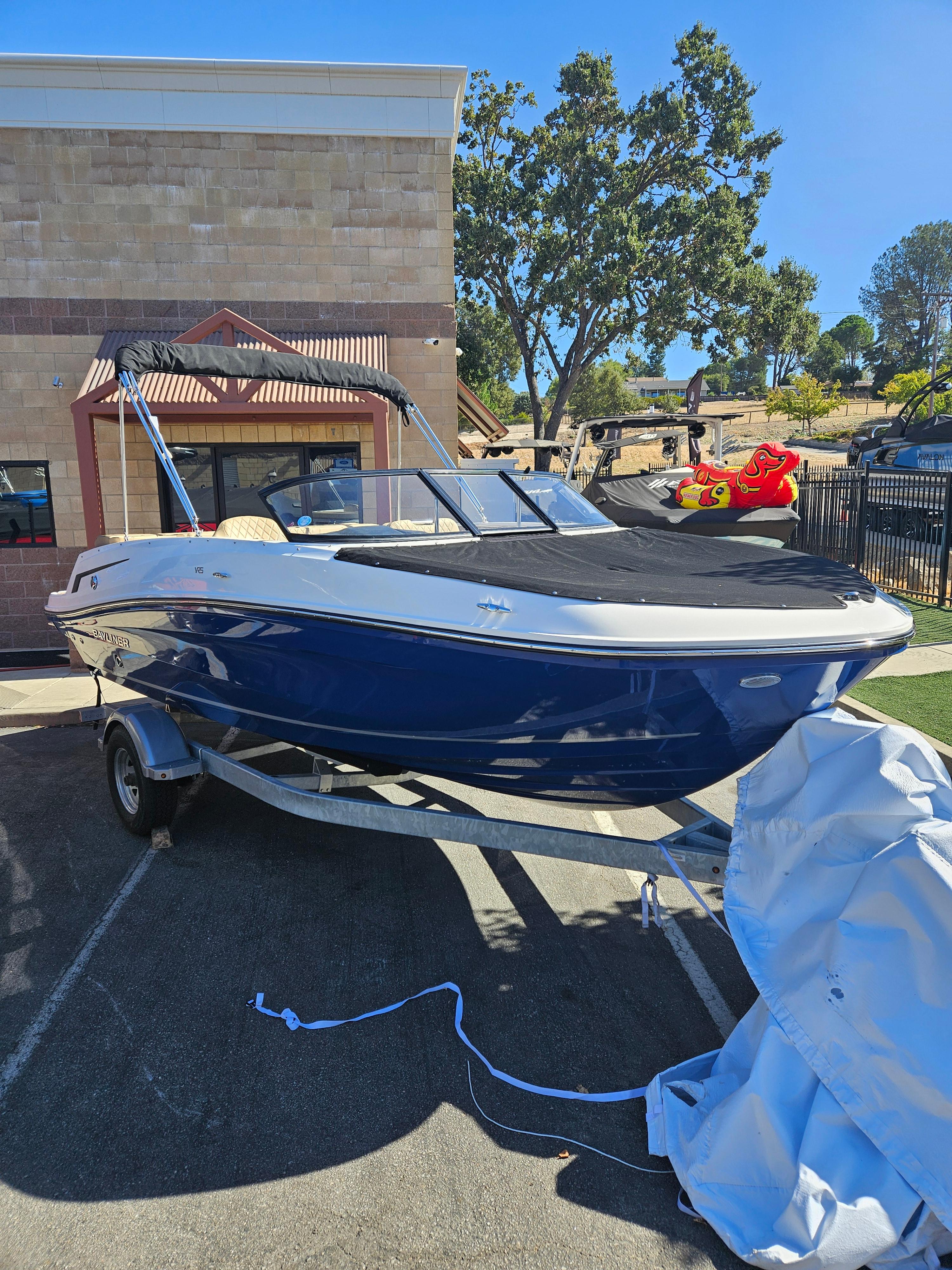 Bayliner VR5 Bowrider 2024 Bayliner VR5 Bowrider boat on trailer, parked outdoors.