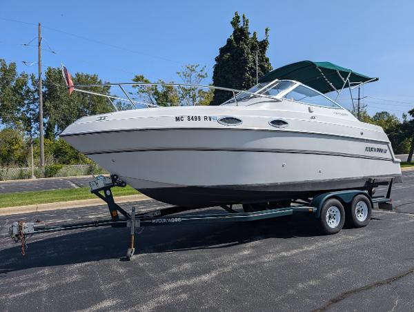 Four Winns 238 Vista 1999 Four Winns 238 Vista boat on trailer, parked outdoors.