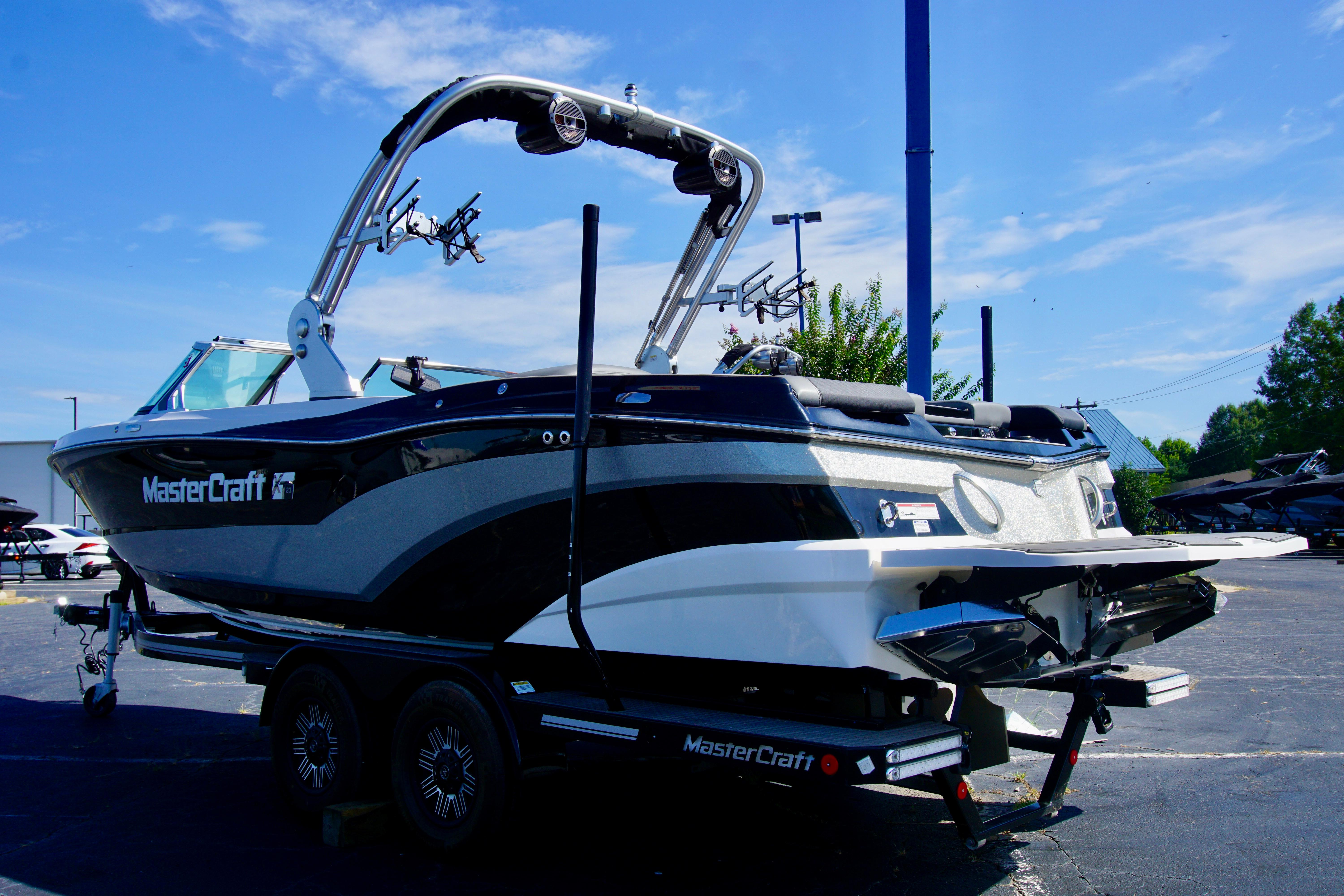 MasterCraft XT23 2019 MasterCraft XT23 boat on trailer under clear blue sky.