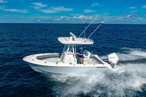 Reef Runner 230 2026 Reef Runner 230 boat cruising on open ocean under clear blue sky.