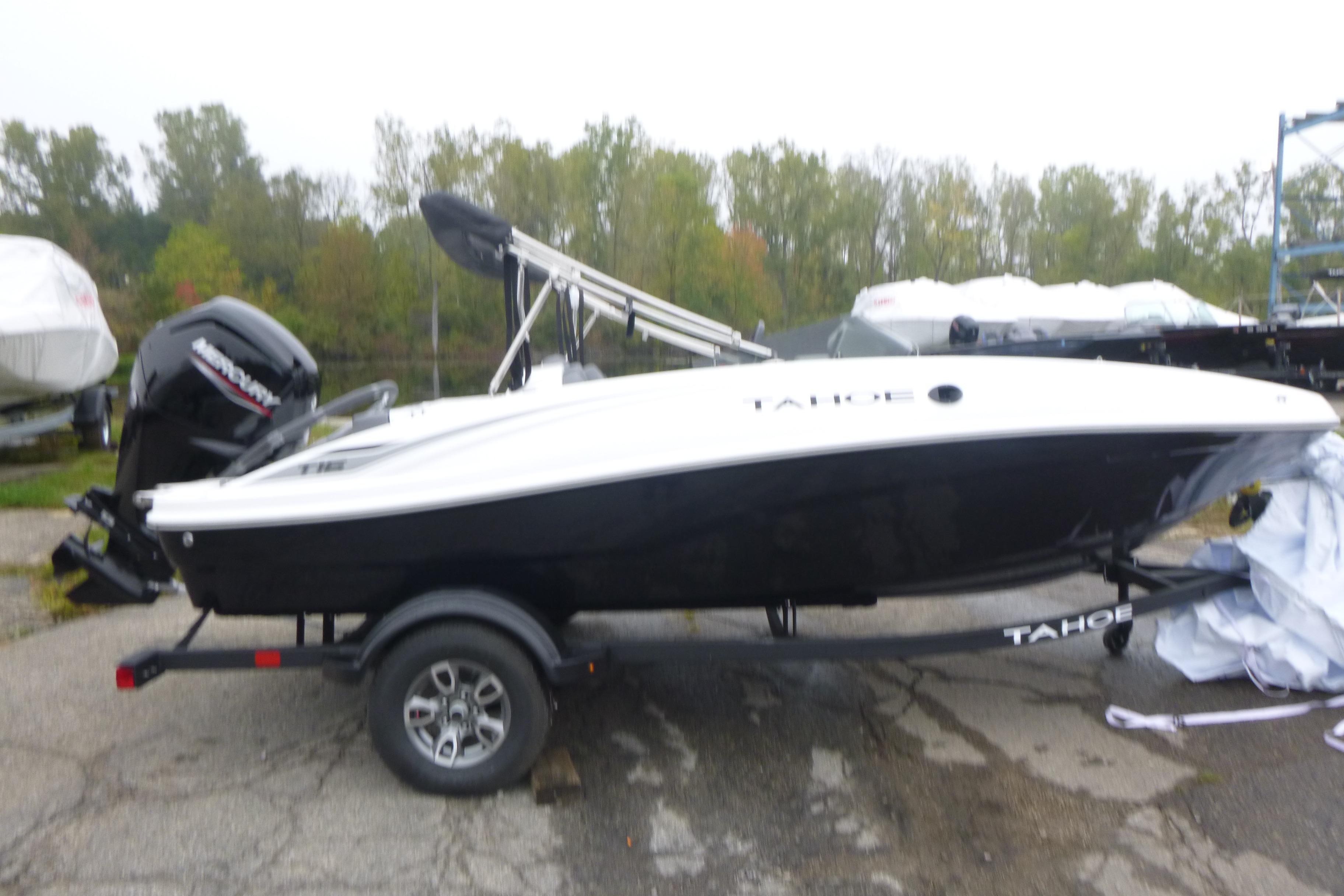Tahoe T16 2026 Tahoe T16 boat on trailer, parked outdoors with trees in background.