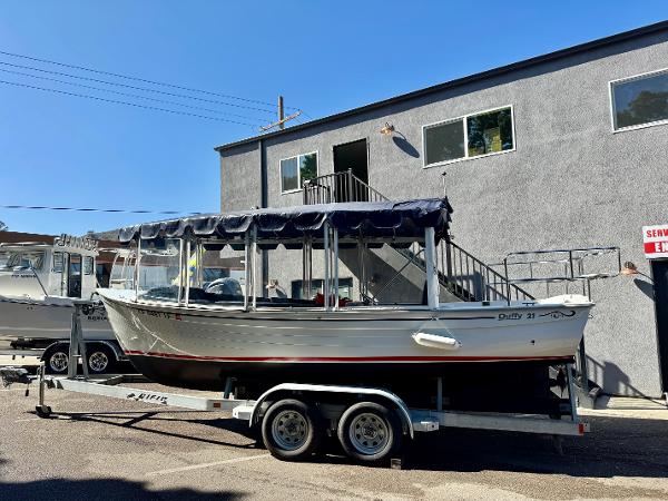 Duffy Sun Cruiser 2022 Duffy Sun Cruiser boat on trailer, parked outside a building.