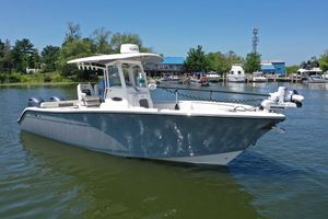 Cobia 280 Center Console 2023 Cobia 280 Center Console boat on calm water, surrounded by greenery and docks.
