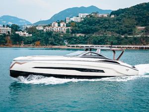 Tecnomar 55 Evo Tecnomar 55 Evo 2019 yacht cruising on scenic water with hills and buildings in the background.