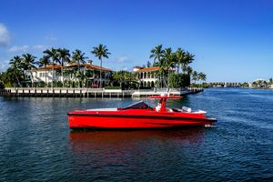 Wally 48 Red 2021 Wally 48 yacht cruising near luxury waterfront homes and palm trees.