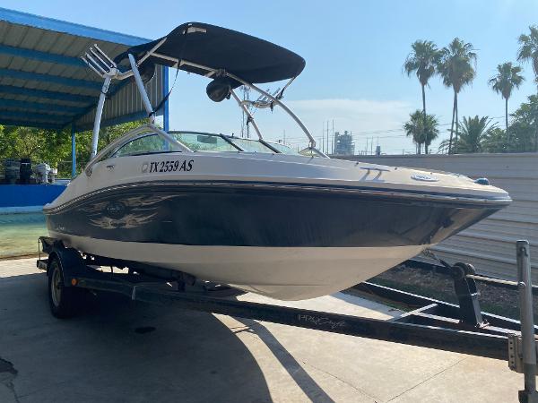 Sea Ray 185 Sport 2008 Sea Ray 185 Sport boat on trailer, under a canopy, with palm trees in background.
