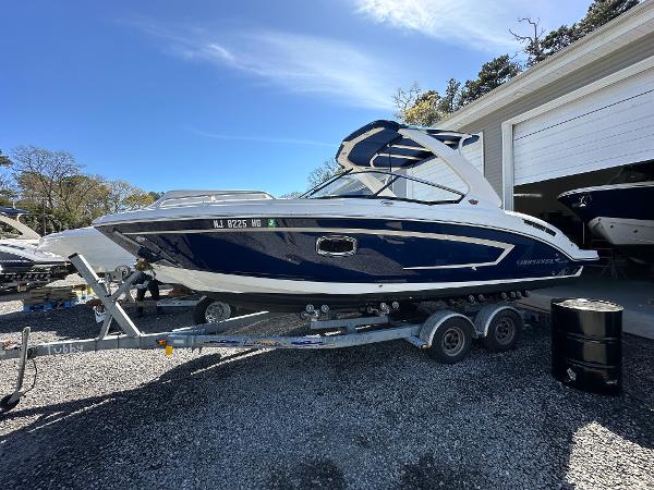Chaparral 257 SSX 2015 Chaparral 257 SSX boat on a trailer outside a garage.