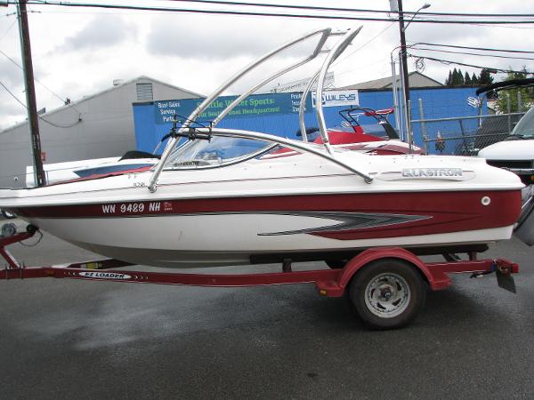 Glastron 175SX 1999 Glastron 175SX boat on a red trailer in a parking lot.