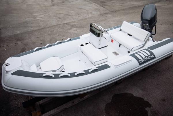 Novurania DL 400 2024 Novurania DL 400 inflatable boat with outboard motor, docked on a concrete surface.