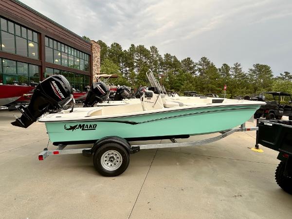 Mako Pro Skiff 15 CC 2025 Mako Pro Skiff 15 CC boat on trailer, parked outdoors near a building.