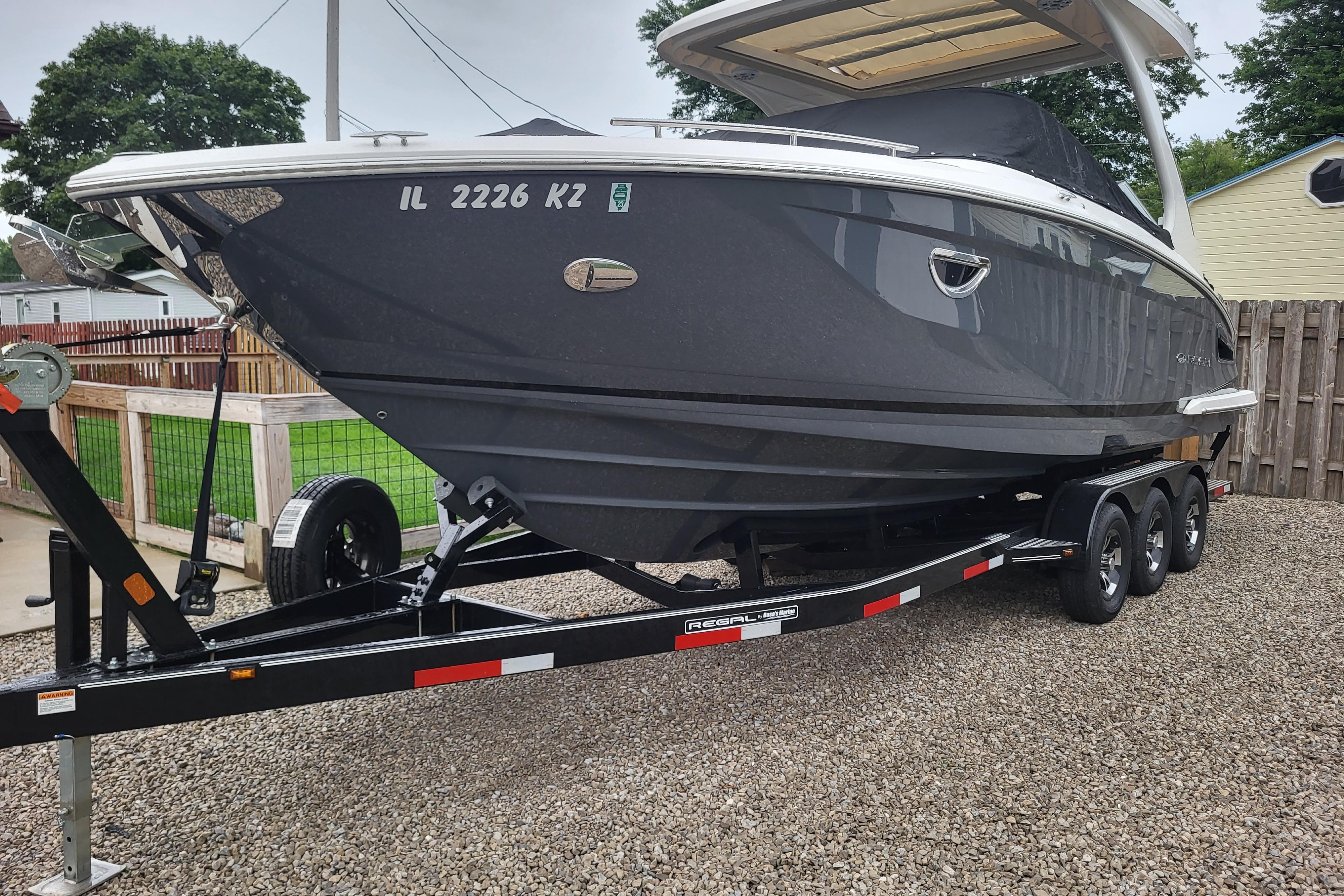 Regal 2800 Bowrider 2019 Regal 2800 Bowrider boat on trailer, parked on gravel driveway.