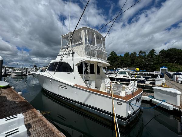 Post 44 Sport Fisherman 1990 Post 44 Sport Fisherman yacht docked at marina under cloudy sky.