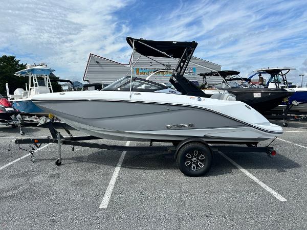 Scarab 195 SE 2025 Scarab 195 SE boat on trailer, parked in a lot under a cloudy sky.