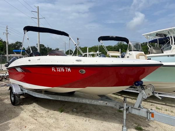 Bayliner Element E18 2023 Bayliner Element E18 boat in red on a trailer, parked outdoors.
