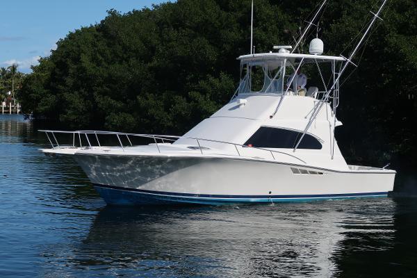 Luhrs 40 Convertible 2002 Luhrs 40 Convertible yacht on calm water near lush greenery.