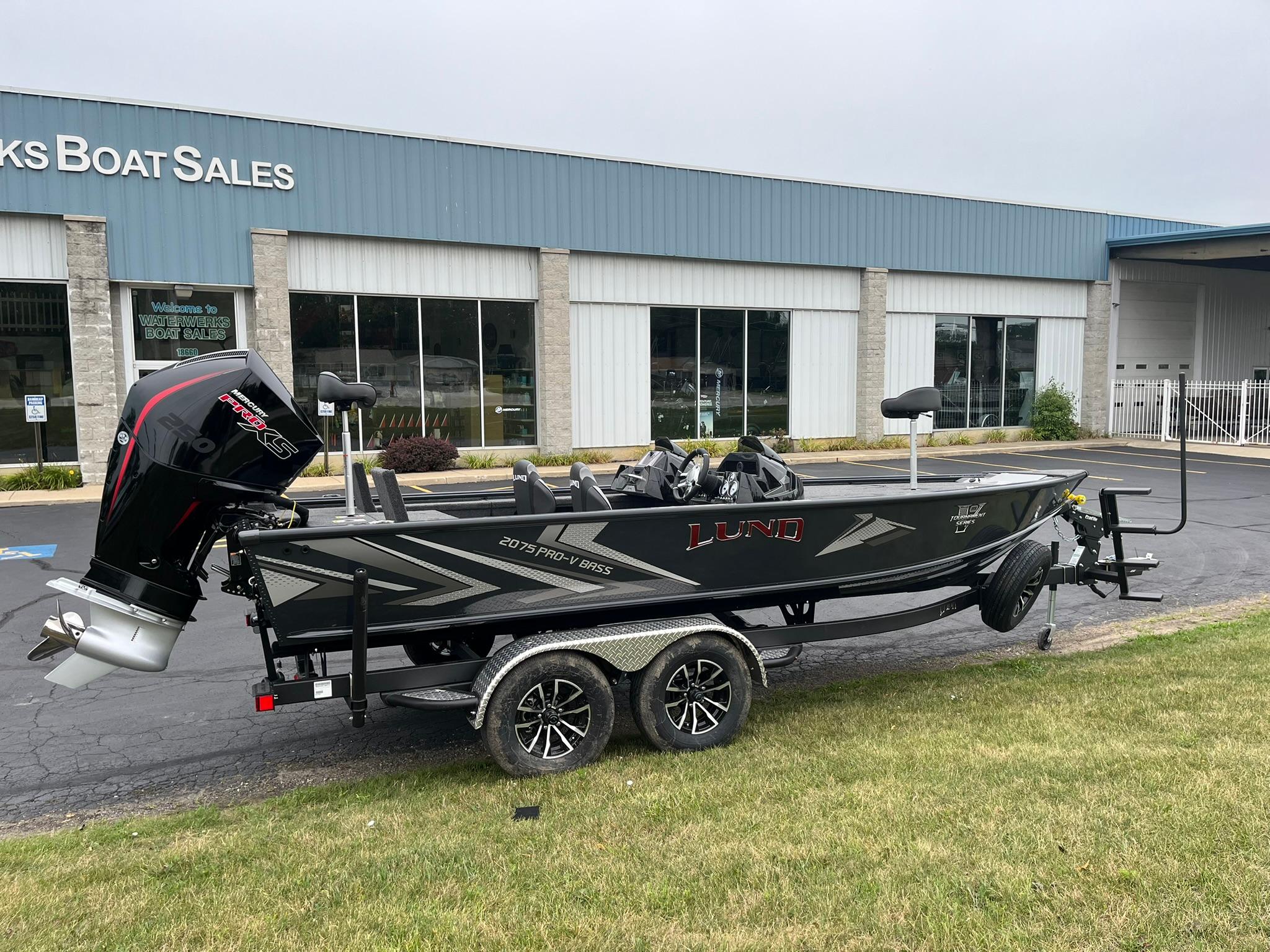 Lund 2075 Pro-V Bass XS 2026 Lund 2075 Pro-V Bass XS boat on trailer outside dealership.